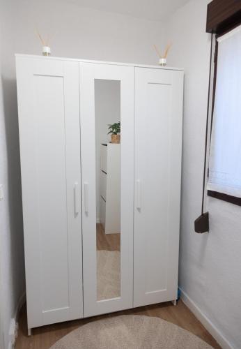 a white cabinet with a mirror in a room at Ametsa !!! VT Cerca de la Playa in Lekeitio