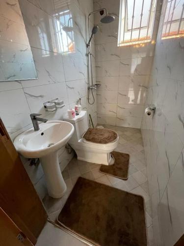 a bathroom with a toilet and a sink at Posh Apartment Munyonyo in Kampala