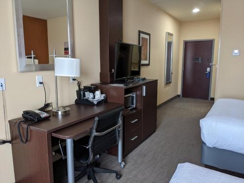 a hotel room with a desk and a bed and a room at Best Western St. Louis Airport North Hotel & Suites in Hazelwood