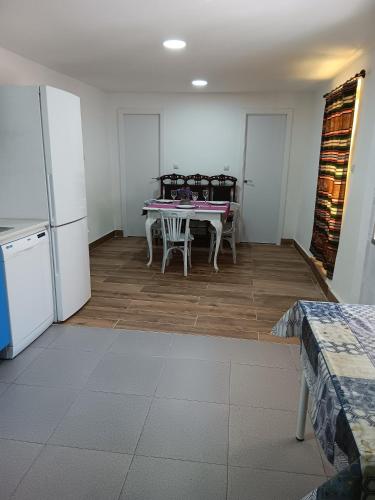 a dining room with a table and a refrigerator at LA CASA DE LOS LIRIOs in Alcabón