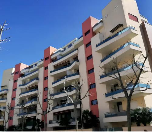 un edificio de apartamentos en rojo y blanco en Sunset Escape, relax a due passi dal mare con terrazza e aria condizionata, en Montesilvano
