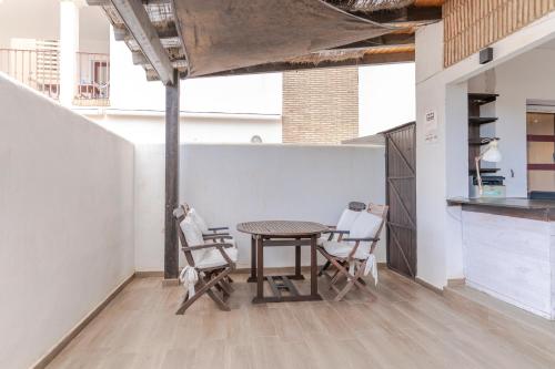 a table and chairs in a room with a counter at RentitSpain Terrazas del sol, Relax Piscina y Golf in Salobreña