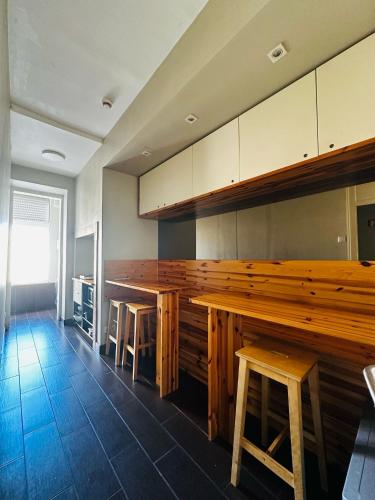 a kitchen with a large wooden table and stools at Hostel Marques de Pombal in Lisbon