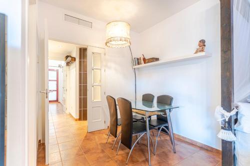 a dining room with a glass table and chairs at RentitSpain Terrazas del sol, Relax Piscina y Golf in Salobreña