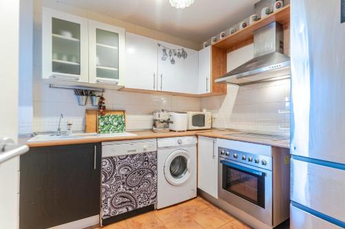 a kitchen with a washing machine and a washer at RentitSpain Terrazas del sol, Relax Piscina y Golf in Salobreña