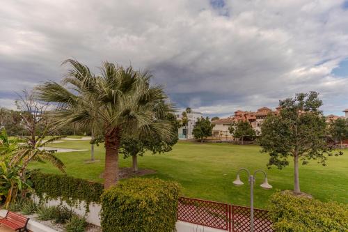 a view of a park with palm trees and buildings at RentitSpain Terrazas del sol, Relax Piscina y Golf in Salobreña