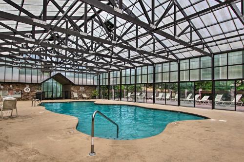 a large swimming pool in a building with windows at 1 Mi to Dollywood Quiet Cabin with Hot Tub! in Sevierville