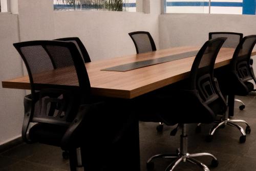 a wooden table with black chairs around it at MOVA - Hotel Costa Azul in Ubatuba