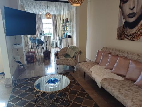 a living room with a couch and a table at Casa adosada cerca del centro y la playa in Alcaidesa