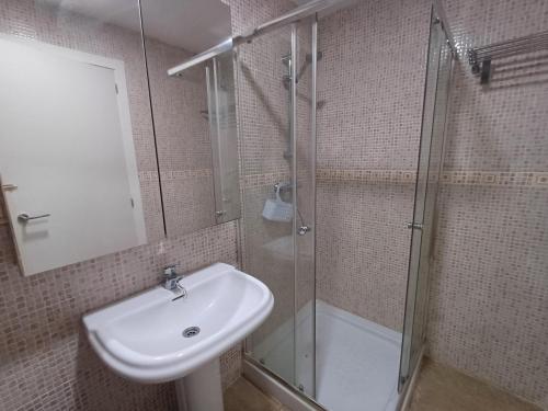 a bathroom with a sink and a glass shower at Casa adosada cerca del centro y la playa in Alcaidesa