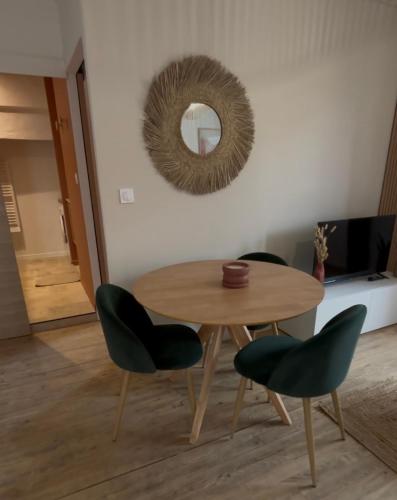 a table and chairs in a room with a mirror at Bel appartement neuf en plein centre in Brantôme