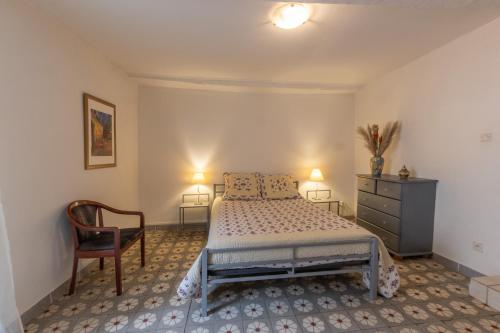 une chambre avec un lit et une chaise dans l'établissement Joli T2 au Cœur de Vals, à Vals-les-Bains