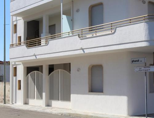 a white building with a balcony on a street at bilo eddy by salentolimit in Torre Lapillo