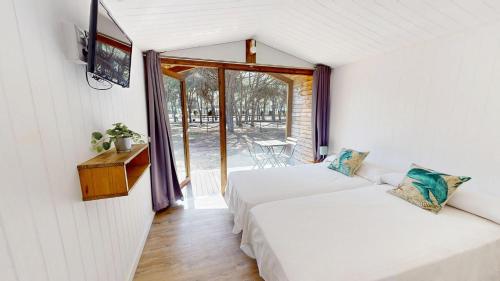 two beds in a small room with a window at Camping Playa Taray in Islantilla