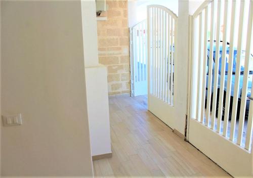 a hallway with white walls and wooden floors and a staircase at bilo eddy by salentolimit in Torre Lapillo