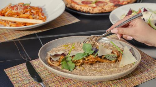 a person is eating a bowl of food on a table at The Abdali Boulevard Hotel in Amman