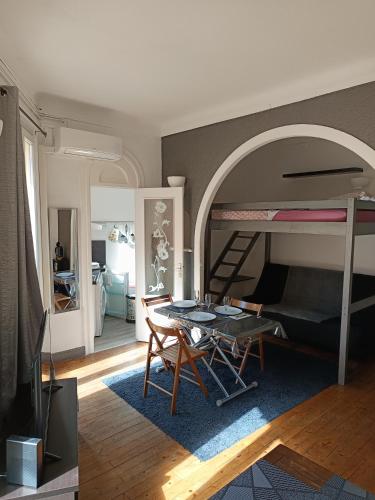 - un salon avec une table et des lits superposés dans l'établissement Charmant studio climatisé centre Villefranche sur mer, à Villefranche-sur-Mer