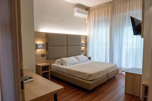 a hotel room with a bed and a television at Hotel St Gregory Park in Rimini