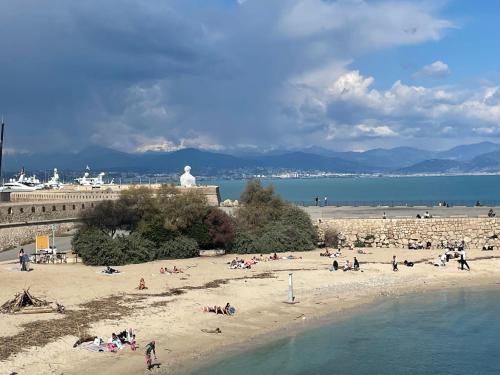 a group of people on a beach near the water at Superbe 2 pièces Antibes vue mer, piscine, parking in Antibes