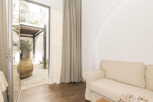 a living room with a white couch and a mirror at Mar Abierto B in Sanlúcar de Barrameda