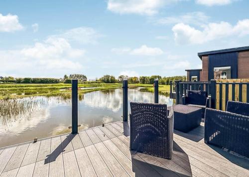 a wooden deck with a view of a body of water at Waterside Hambleton Lakeside Lodges in Poulton le Fylde