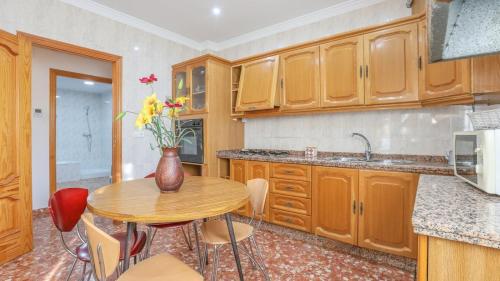 a kitchen with a wooden table and a vase with flowers at Casa Rural El Tejar La Rambla by Ruralidays in Córdoba
