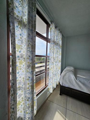 a bedroom with a bed and a window with a view at Hotel posada Juquila in Zacatlán
