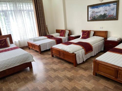 a room with four beds and a painting on the wall at Công Thành hotel in Lao Cai