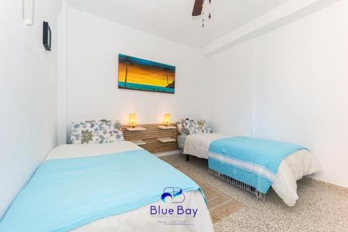Un dormitorio con dos camas y una caja azul. en La Playa APT by Bluebay, en La Herradura