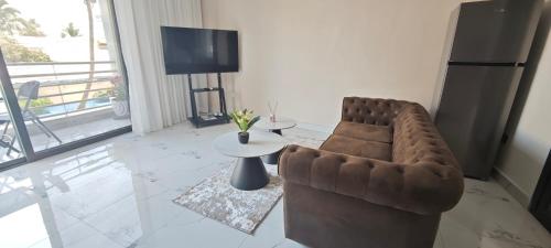 a living room with a couch and a table and a television at Chambres d'Hôtes Centre Ville in Dakar