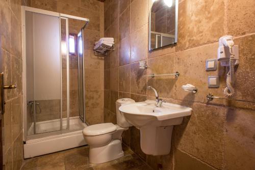 a bathroom with a toilet and a sink and a shower at Kirkit Hotel in Avanos