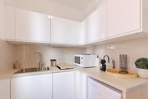 une cuisine blanche avec un évier et un micro-ondes dans l'établissement Cannes Loft 1 bedroom - 3R, à Cannes