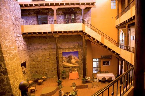 an old building with a staircase and tables and chairs at El Meson de los Poetas in Guanajuato
