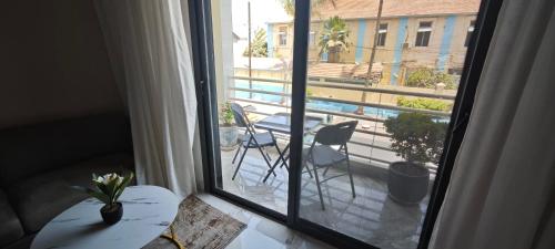 a window with a view of a patio with a table and chairs at Chambres d'Hôtes Centre Ville in Dakar