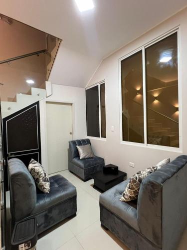 a living room with two couches and a tv at Hotel Tonaka in Santo Domingo de los Colorados