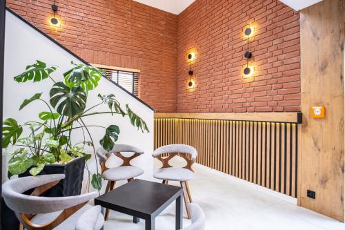a room with three chairs and a table and a brick wall at Azymut 48C in Stary Folwark
