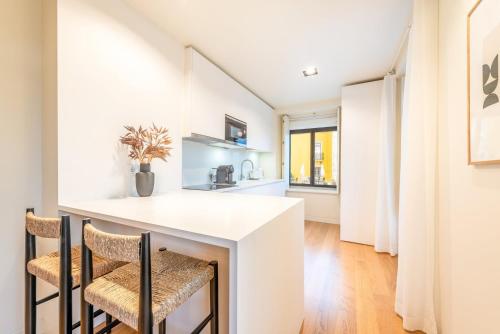 a kitchen with a white table and chairs at GuestReady - Conde das Alcáçovas in Paço de Arcos