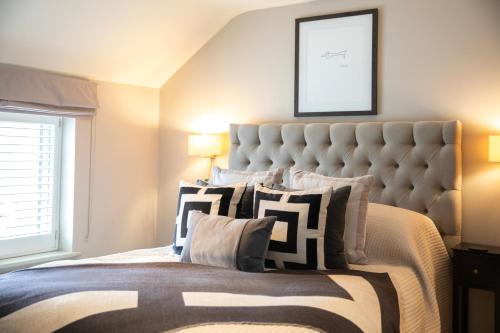 a bedroom with a large bed with a large headboard at The Fuzzy Duck in Newbold on Stour