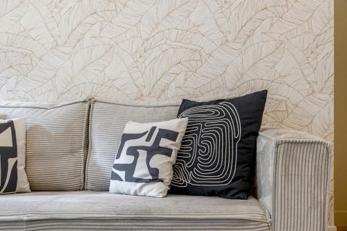 - un canapé avec deux oreillers et un mur dans l'établissement A31#Republique # 1BedRoom # Marais # Paris03 # AC, à Paris