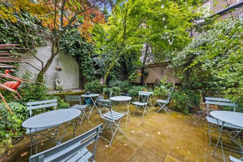 a group of tables and chairs in a garden at Vancouver Hotel and Studios in London