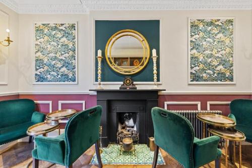 a living room with a fireplace and a mirror at Vancouver Hotel and Studios in London