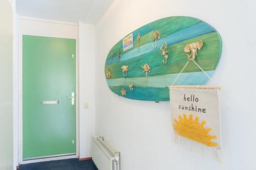 a surfboard hanging on a wall in a hallway at Vakantiehuis, Villapark Oesterbaai 39, aan zee, grenzend aan speeltuin in Wemeldinge
