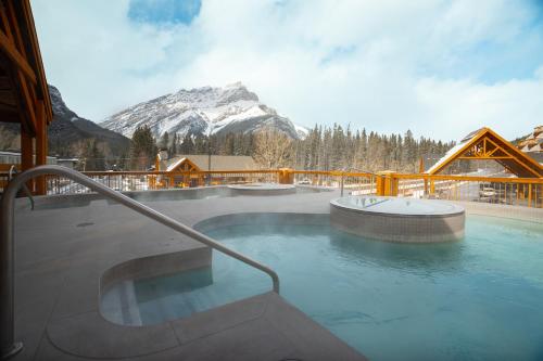 a hot tub with a mountain in the background at Otter Hotel in Banff