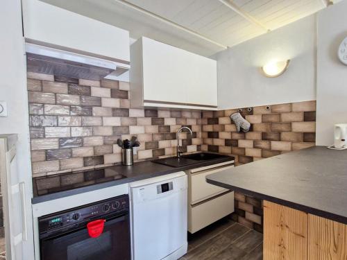 une cuisine avec un évier et un lave-vaisselle dans l'établissement Appartement confortable à Flaine - 150m des pistes - 6 pers, balcon, cuisine équipée, lave-linge - FR-1-425-144, à Flaine