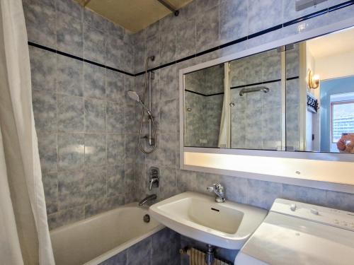 une salle de bain avec un lavabo, une baignoire et un miroir dans l'établissement Appartement confortable à Flaine - 150m des pistes - 6 pers, balcon, cuisine équipée, lave-linge - FR-1-425-144, à Flaine