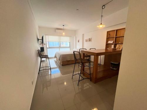 una habitación con una cama, una mesa y sillas en Studio en Paseo la Cisterna 712, en Buenos Aires