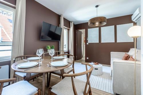 une salle à manger avec une table et des chaises et une télévision dans l'établissement B41#République#Marais#1BedRoom#Paris03#AC, à Paris