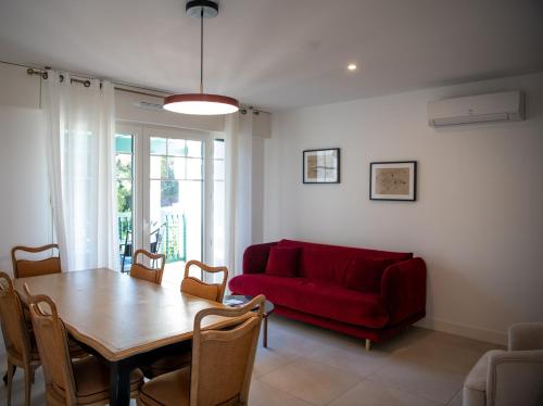 a living room with a red couch and a table at Villa Aitama in Cap-Ferret