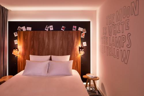 a bedroom with a bed with a wooden head board at Mama Shelter Belgrade in Belgrade