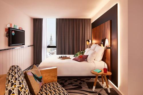 a hotel room with a bed and a tv at Mama Shelter Belgrade in Belgrade